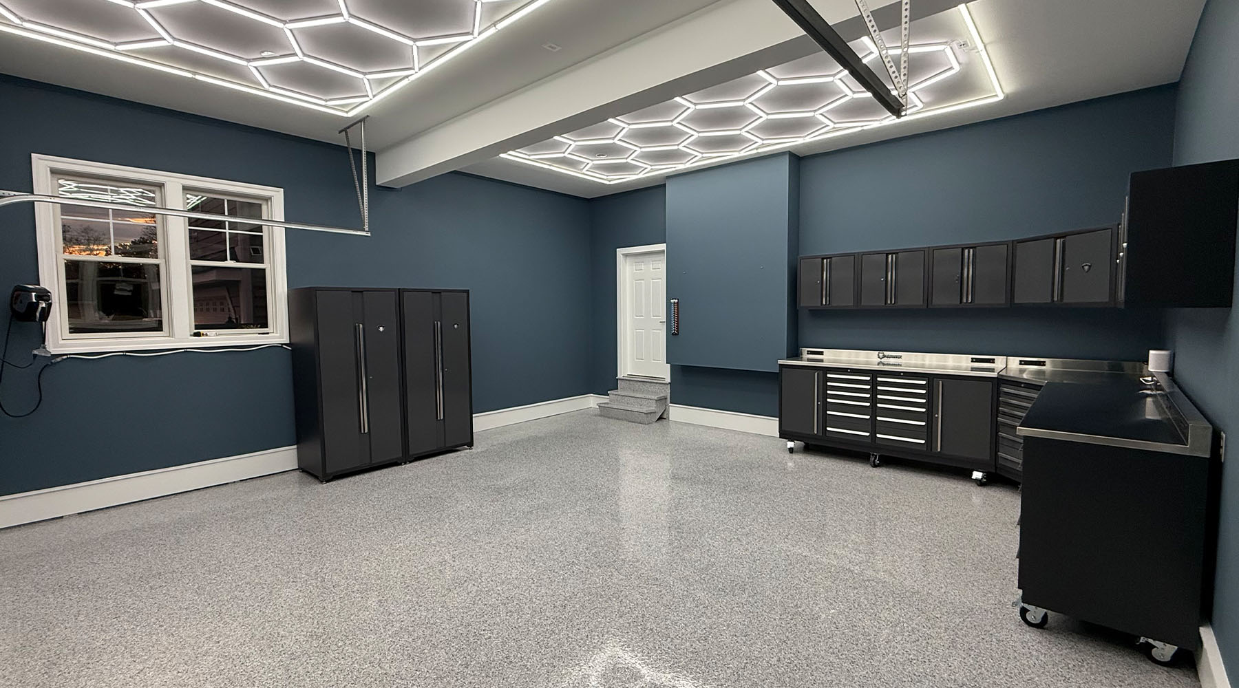 Dragonfire garage storage solutions in a garage with epoxy flooring and LED honeycomb lighting.